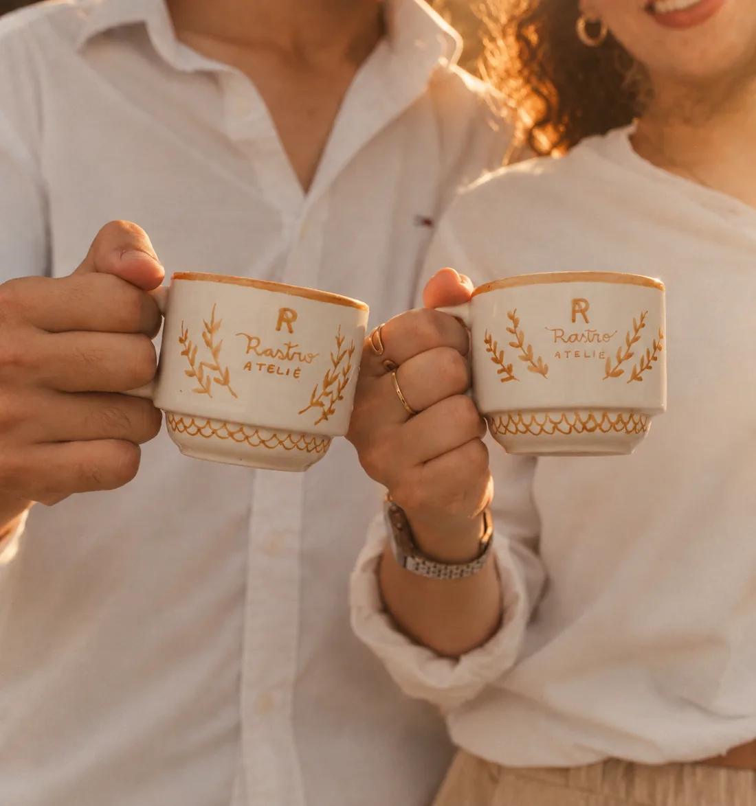Casal segurando duas xícaras personalizadas da Rastro Ateliê